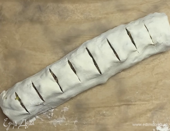 Выкладываем на противень, застеленный пергаментом, швом вниз и делаем сверху надрезы. Ставим в духовку при 180°C на 25–30 минут.