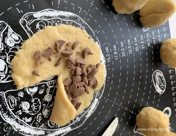 Разделить тесто на 16 частей, каждую из которых раскатать в круг, посыпать тертым шоколадом, разрезать до центра и сворачивать по кругу. У основания конуса защипнуть края, чтобы «Бутоны» были устойчивыми.