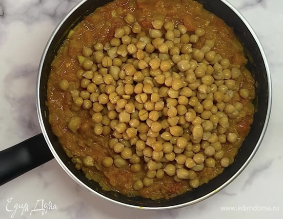 Берем банку томатов в собственном соку или 2–3 помидора и нарезаем на средние кусочки. Добавляем в сковороду и тушим пару минут до размягчения. В овощи выкладываем отваренный нут, наливаем кокосовое молоко. Ставим тушиться под крышкой на небольшом огне на 25 минут.
