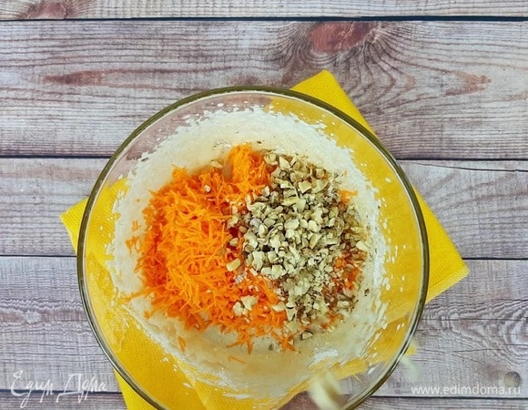Всыпаем муку в яичную смесь, размешиваем. Добавляем тертую на мелкой терке сырую морковь, обжаренные и рубленые орехи.