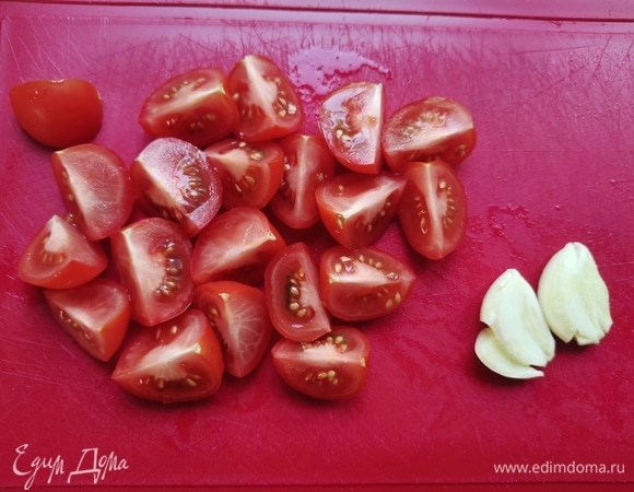 Подготовим все ингредиенты: помидоры черри вымыть, обсушить и нарезать на четыре части. Чеснок почистить, раздавить ножом и порубить в мелкую крошку.