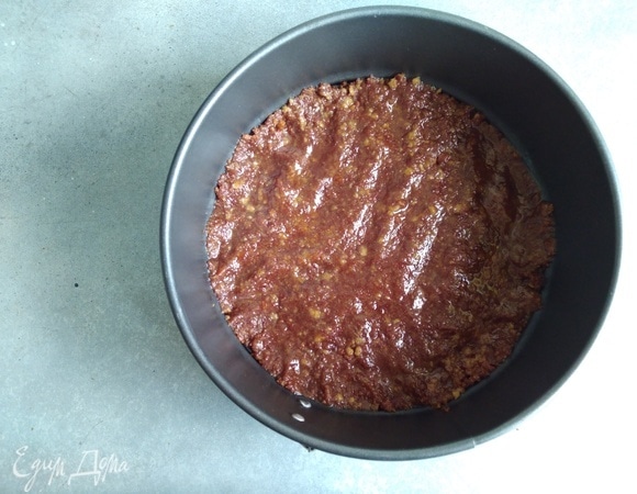 Взять разъемную форму или кольцо диаметром 18–20 см. Утрамбовать крошку по дну, хорошо прижимая пальцами. Убрать в морозилку на 15 минут.