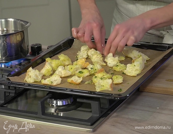 Чиабатту порвать руками на небольшие кусочки, выложить на застеленный бумагой для выпечки противень, смазать чесночным маслом и запекать в разогретой духовке 5 минут.