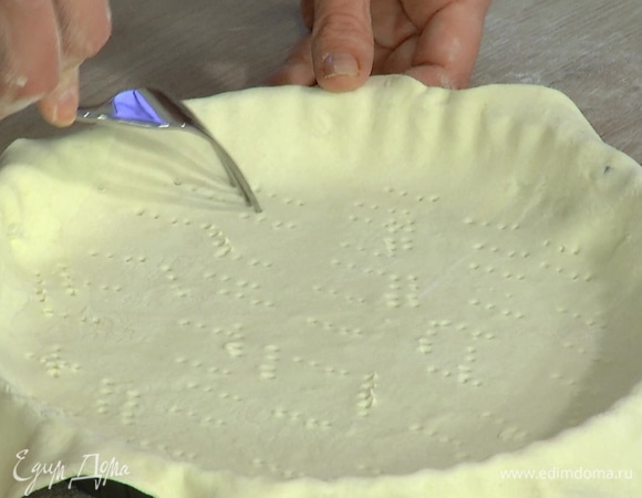 Часто наколоть тесто вилкой, накрыть бумагой для выпечки, засыпать любыми бобовыми и отправить в разогретую духовку на 15–20 минут.