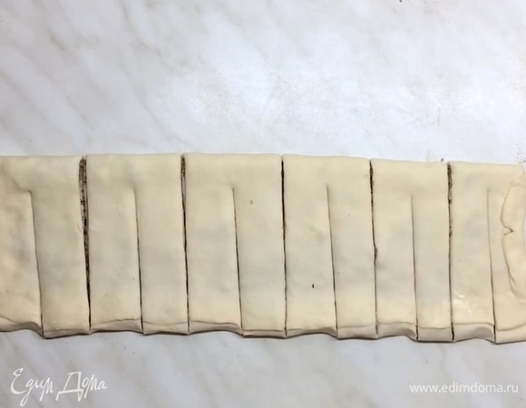 Получается длинный прямоугольник, разрезаем его ножом на одинаковые прямоугольники. Теперь посередине каждого делаем длинный надрез. Каждый кусочек теста скручиваем и соединяем хорошо края. Если высыпались орешки, просто посыпьте ими сверху.