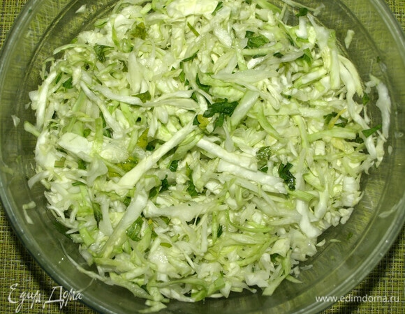 Капусту используем молодую, в ингредиентах указан вес уже нашинкованной капусты. Куриные яйца отварить, остудить, очистить и некрупно нарезать. Капусту нашинковать. Петрушку мелко порубить. Складываем в миску капусту и петрушку, добавляем щепотку соли и мнем руками, чтоб образовался сок, но не увлекайтесь.