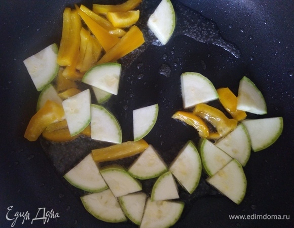 Макароны поставить вариться в подсоленной воде. В сковороде разогреть масло. Добавить нарезанный перец и кабачок. Подрумянить 1 минуту.