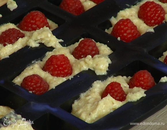 Форму для финансье заполнить тестом на 2/3 объема, затем в каждую ячейку поместить по 3 ягоды малины и слегка утопить их в тесто.