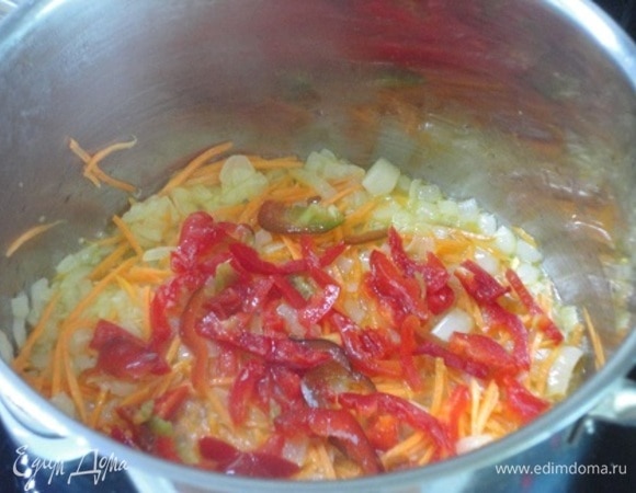 Непосредственно сам суп начинаем готовить прямо в кастрюле с толстым дном — обжариваем лук, морковь и красный болгарский перец. В готовую зажарку вливаем горячий бульон и выкладываем перловую крупу. Варим до готовности крупы.