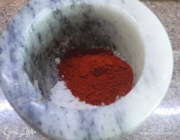 Готовим заправку — растираем чеснок с солью в ступке и смешиваем с красной сладкой паприкой.
