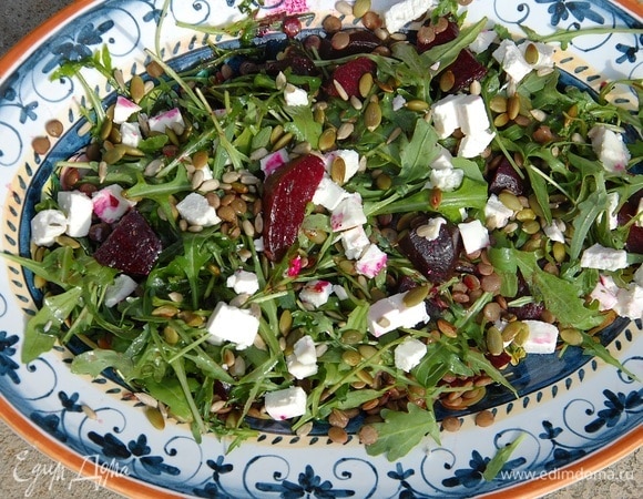 В глубокое блюдо выложить руколу, свеклу и чечевицу, полить все заправкой и перемешать, сверху разложить кубики феты и посыпать семечками.
