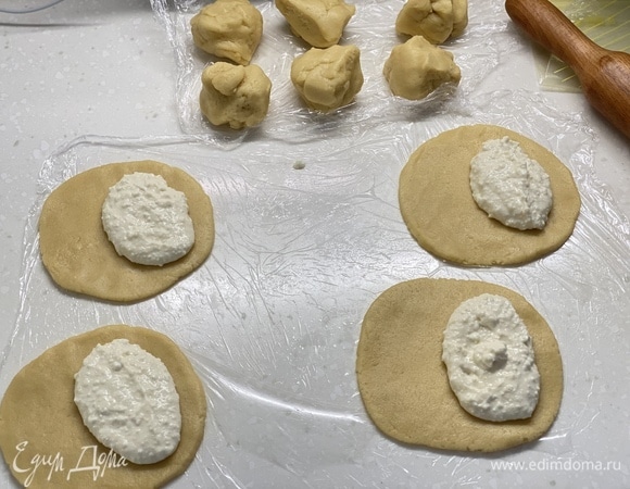 Разделить тесто на 10 частей, каждую раскатать в лепешку, на одну половину лепешки выложить начинку, так проделать с остальными.