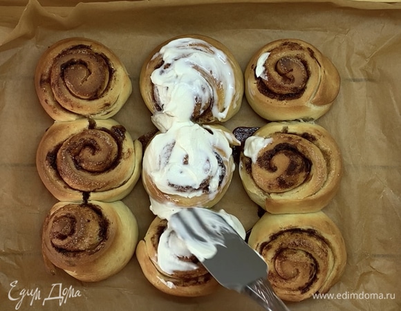 Достаем из духовки булочки и смазываем их кремом.