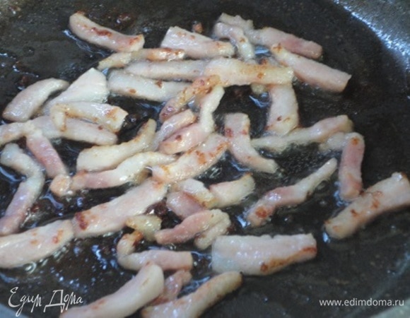 Бекон измельчите и обжарьте на сковороде. Здесь же обжарьте сосиски до хрустящей корочки.