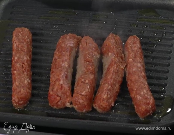 Разогреть в сковороде-гриль оливковое масло и жарить колбаски до готовности.