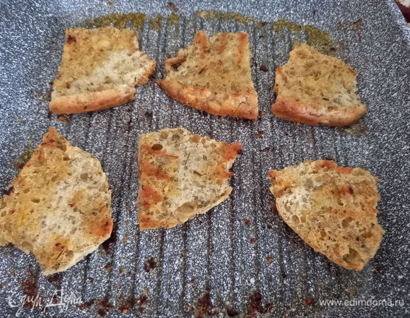 На сковороду, где жарился бекон, выкладываем кусочки хлеба и обжариваем по 2 минуты с каждой стороны. Хлеб впитает в себя жир от бекона и станет хрустящим.