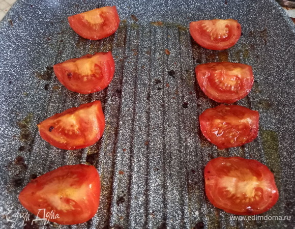 Все на той же сковороде обжариваем томаты, политые оливковым маслом. Сначала их нужно обжарить с одной стороны, потом — с другой, а напоследок — на кожуре.