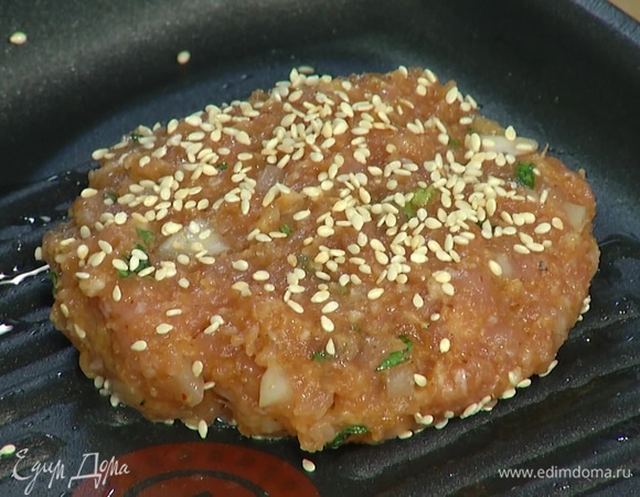 Разогреть сковороду-гриль, сформировать из фарша две котлеты, с одной стороны присыпать кунжутом, выложить на горячую сковороду присыпанной стороной, сверху тоже присыпать кунжутом. Обжарить до готовности с двух сторон.
