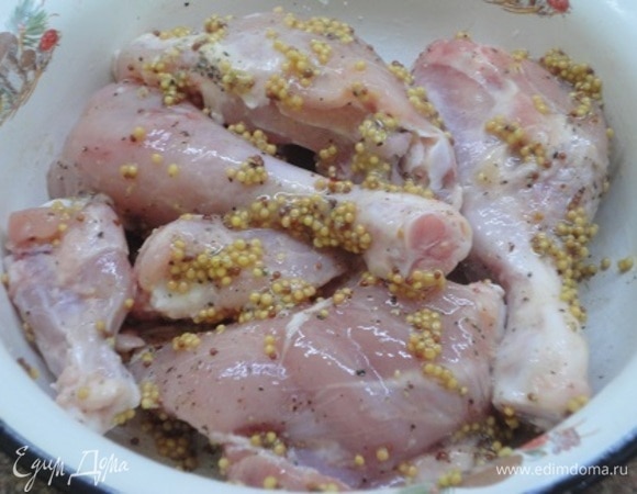 Приготовление блюда я начала с курицы. Ножки разделила на голени и бедра, добавила две верхние части крыльев. Смазала горчицей, поперчила, посолила и оставила мариноваться.