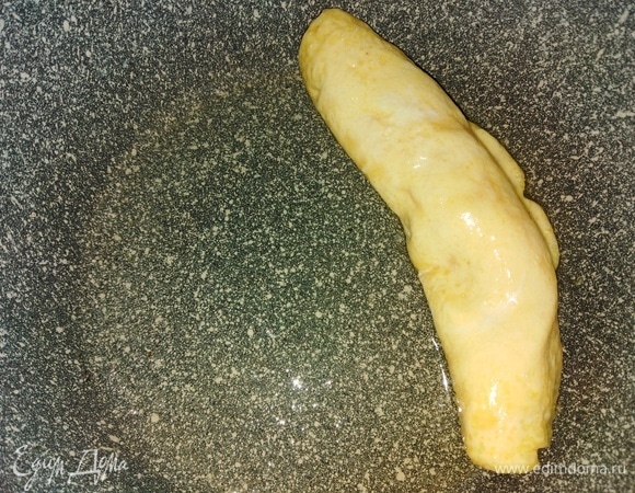 Свернуть в рулет. Отодвинуть к краю сковороды.