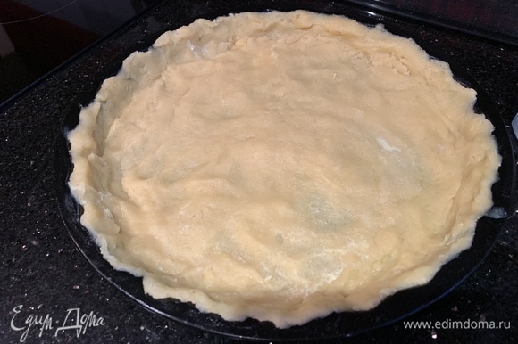 Тонким слоем выложите тесто в форму для запекания, формируя бортики. Наколите вилкой и уберите в холодильник на 30 минут.