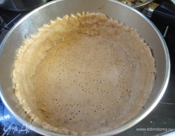 Дно разъемной формы (20 см) я застелила пекарской бумагой, смазав ее слегка растительным маслом. Тесто распределяем по форме, сформировав бортики. Дно накалываем вилкой.