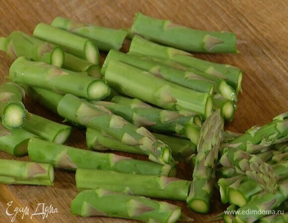 Спаржу, удалив грубые черенки, разрезать на несколько частей.