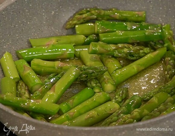 Разогреть в сковороде оливковое масло и обжарить спаржу так, чтобы она осталась ярко-зеленого цвета, была упругой, но не хрустела.