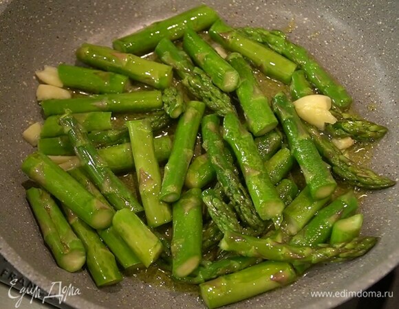 Чеснок почистить, раздавить плоской стороной ножа и добавить к спарже, все посолить и перемешать.