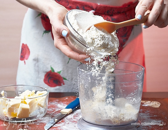 В чашу измельчителя положите часть муки и холодное масло, порубленное кубиками.