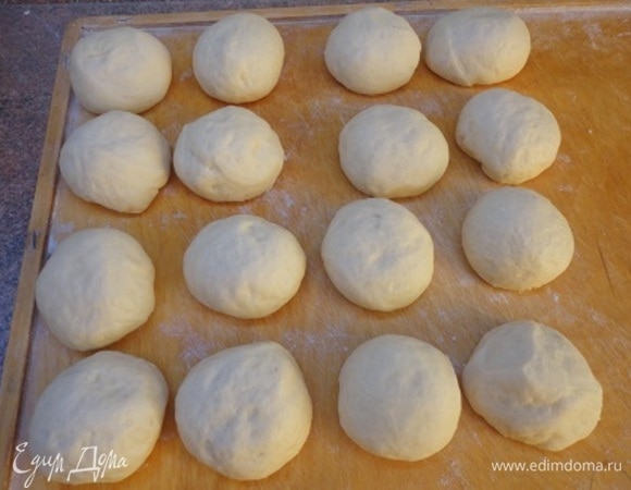 Подошедшее тесто слегка обмять, разделить на равные части. У меня получилось 16 шт. по 65 г примерно. Тесто собрать в центр и прокрутить в руках, чтобы получился гладкий шарик.