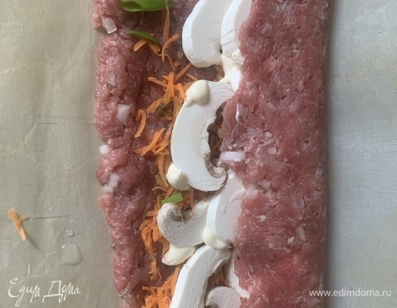 Сворачиваем рулетом, подкручивая коврик. Края рулета залепить фаршем, чтобы начинка была полностью закрыта.