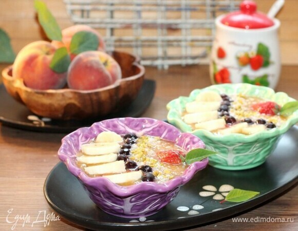 Разлейте фруктовое пюре по мискам. Украсьте смузи ягодами, фруктами, кокосовой стружкой, обжаренными и измельченными орешками и листиком мяты.