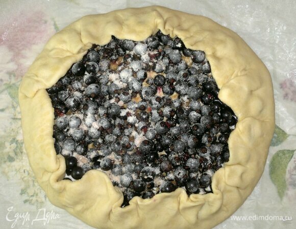 Завернуть края теста. Перенести пергамент с галетой на противень и поставить в духовку, разогретую до 180°C. Выпекать 35–40 минут.