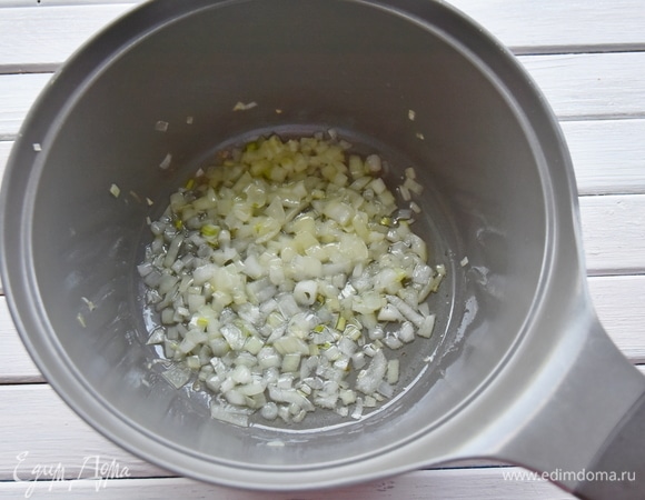 В кастрюлю с толстым дном влить растительное масло и пассеровать мелко нарезанный репчатый лук.