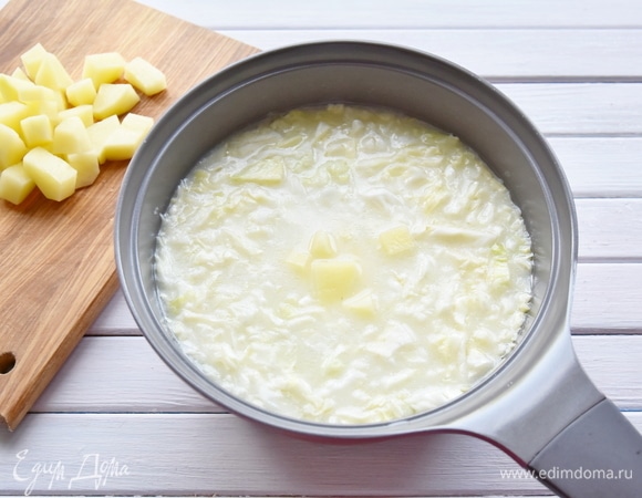 Долить в кастрюлю оставшийся бульон. Выложить в суп нарезанный кубиками картофель и варить на медленном огне до готовности картофеля.