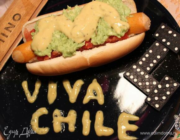 В середину хлеба выложите квашеную капусту, положите сосиску, затем по краям сосиски выложите помидоры, намажьте сверху авокадо и полейте майонезом.