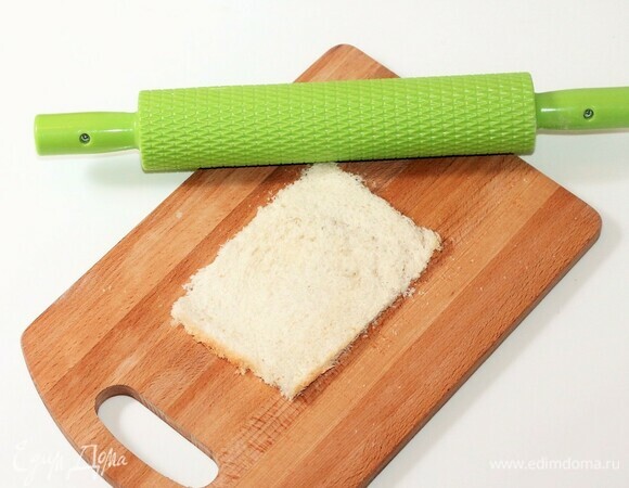 Берем 3 кусочка хлеба для тостов и отрезаем аккуратно корочку. Раскатываем кусочки хлеба скалкой.