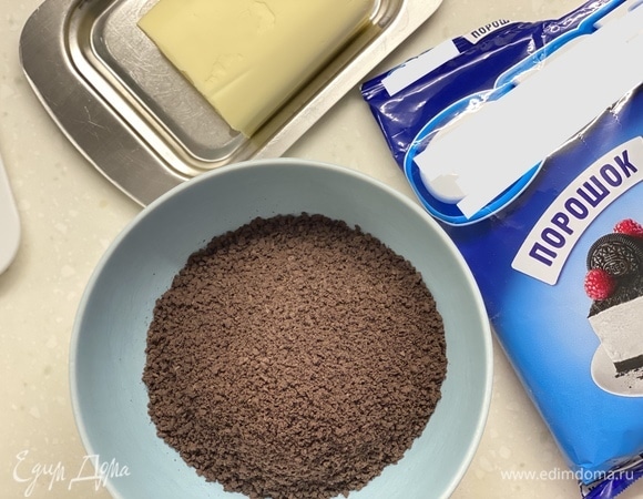 Крошку печенья «Орео» смешать с растопленным маслом. Я использовала готовую крошку, но, конечно, можно измельчить и печенье «Орео». Выложить смесь на дно формы для выпечки, убрать в холодильник.