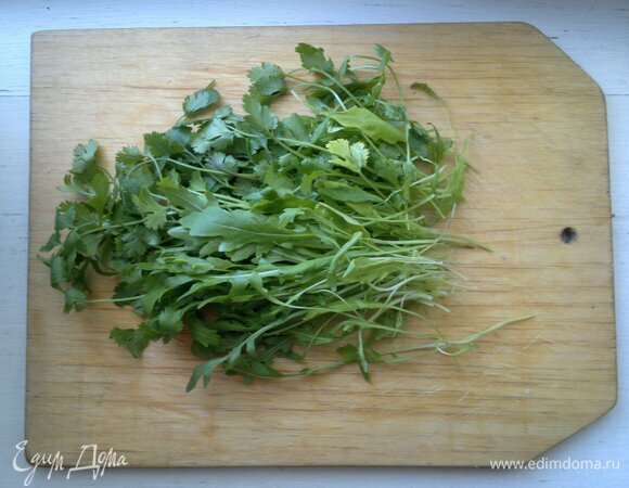 Руколу и кинзу вымыть, обсушить, мелко нарезать.