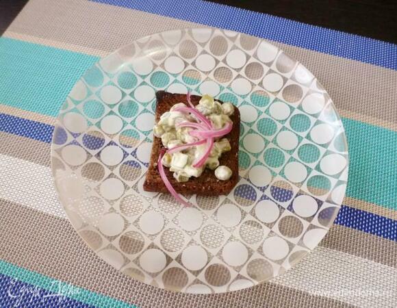 На кусочки поджаренного хлеба положить огуречный салат, а сверху — отжатый от уксуса лук.