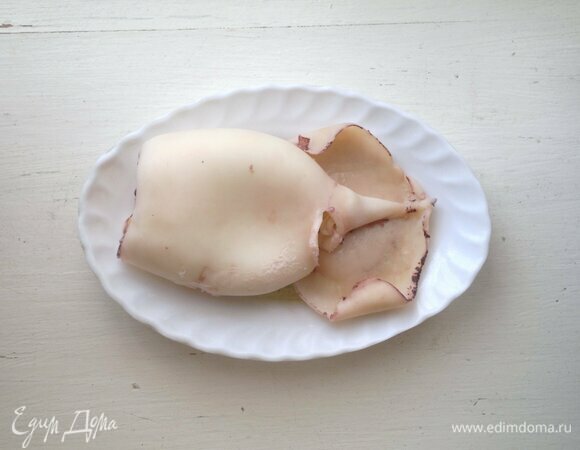 Кальмара заранее разморозить в холодильнике. Кальмара вымыть, отварить в кипящей подсоленной воде в течение 3 мин. Остудить под холодной водой, почистить от пленок и пластин.