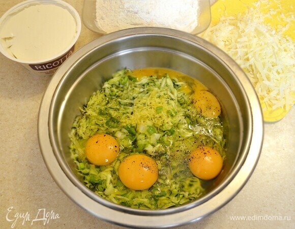 Цукини помыть, обсушить, натереть на крупной терке, слегка посолить и дать постоять 10 мин. Затем необходимо отжать жидкость. В миску к цукини добавить мелко нарезанный зеленый лук, натертую на мелкой терке цедру одного лимона, яйца, масло, перец и хорошо перемешать. Просеять муку, добавить разрыхлитель и вмешать в общую массу. Далее добавьте натертый пармезан и рикотту (текстура готовых маффинов интереснее получается, если оставить немного небольших неразмешанных кусочков).