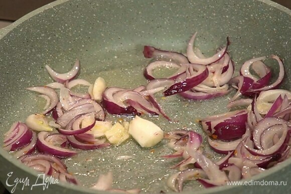 Разогреть в сковороде оливковое масло, выложить лук с чесноком, посыпать паприкой, слегка посолить и обжарить до прозрачности.