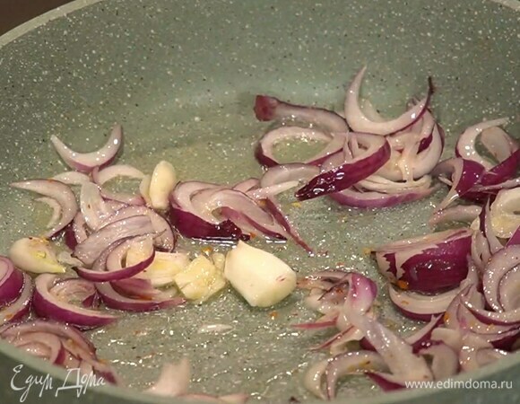 Разогреть в сковороде оливковое масло, выложить лук с чесноком, посыпать паприкой, слегка посолить и обжарить до прозрачности.