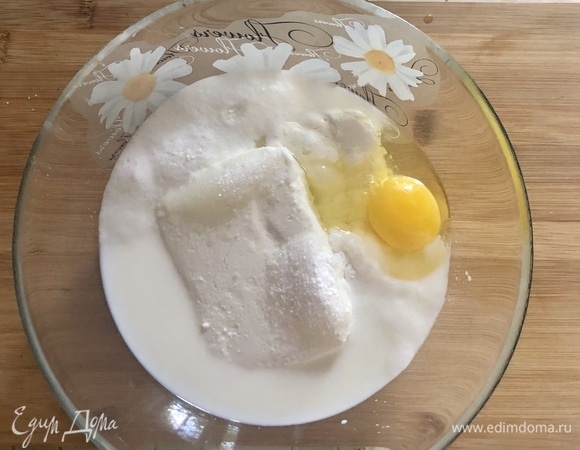 К творогу добавить теплое молоко, яйцо, сахар, ванильный сахар, соль и разрыхлитель, пробить блендером до однородности.