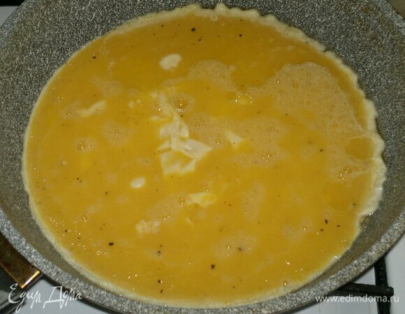 В другой сковороде разогреть оставшееся растительное масло. Вылить в сковороду взбитые яйца. Подождать, пока схватятся низ и бока омлета.