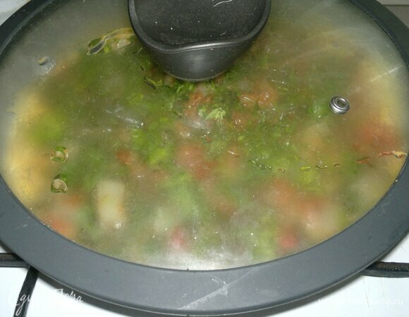 Накрыть сковороду с омлетом крышкой и готовить на малом огне еще 5 мин.