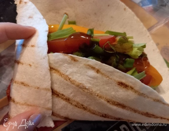 Аккуратно сворачиваем лепешку: вначале сгибаем с одной стороны, потом снизу и закрываем оставшейся стороной.