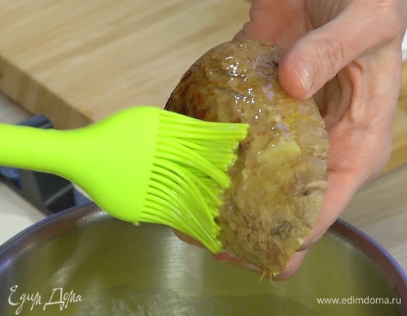 Картофельные чашечки смазать со всех сторон растопленным маслом и выложить на застеленный бумагой для выпечки противень кожурой вниз.